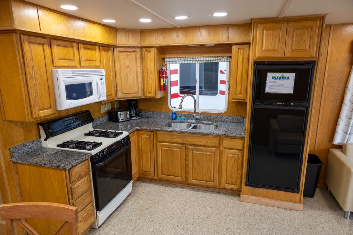a kitchen with a microwave on top of a wooden floor