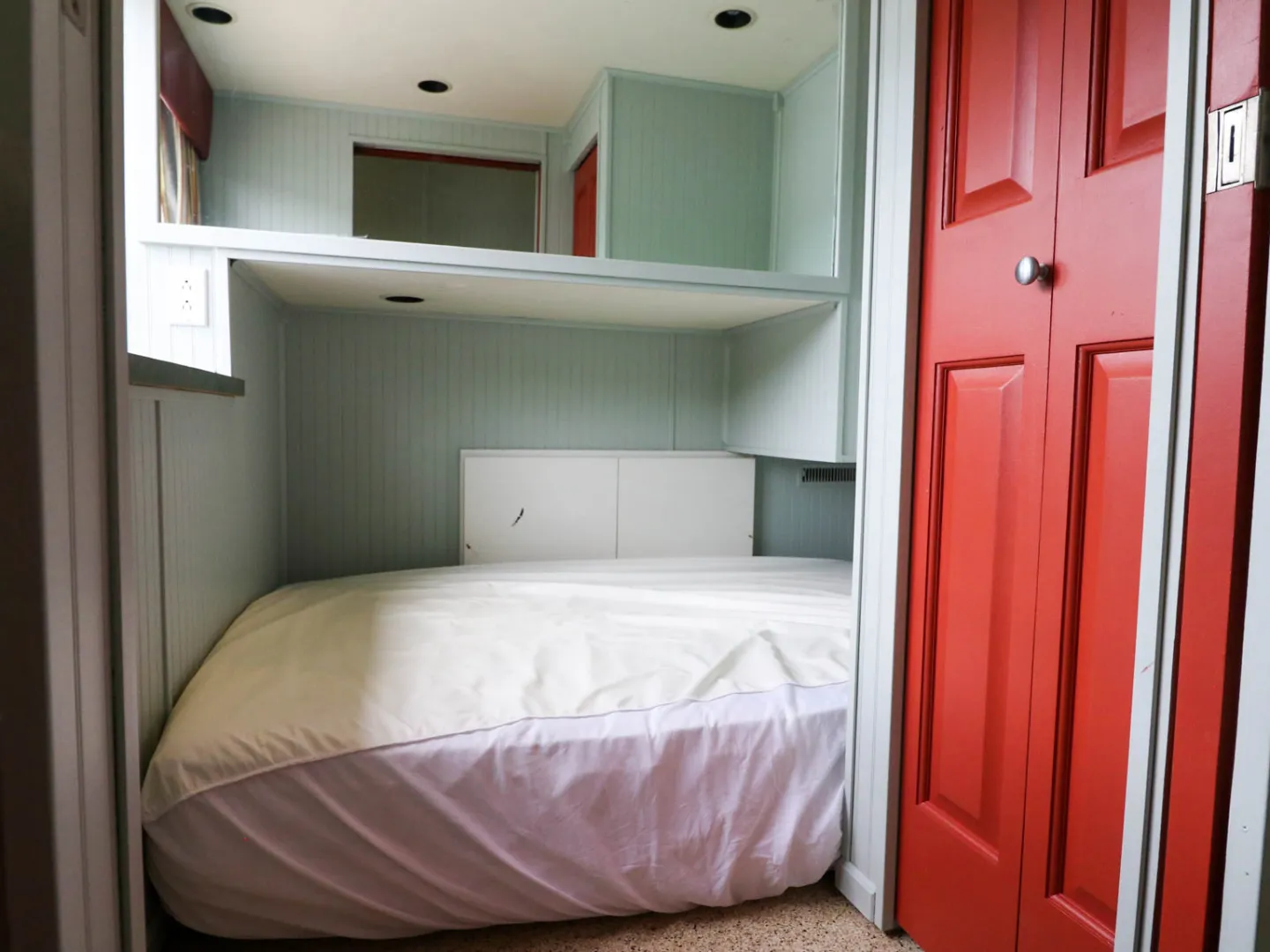 a bedroom with a bed a dresser and a door