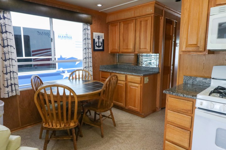 a kitchen with wooden cabinets and a dining room table