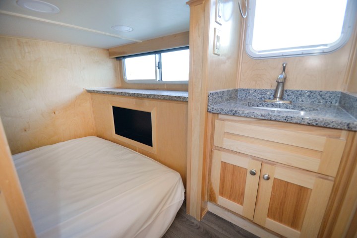 a bedroom area with a sink and a window