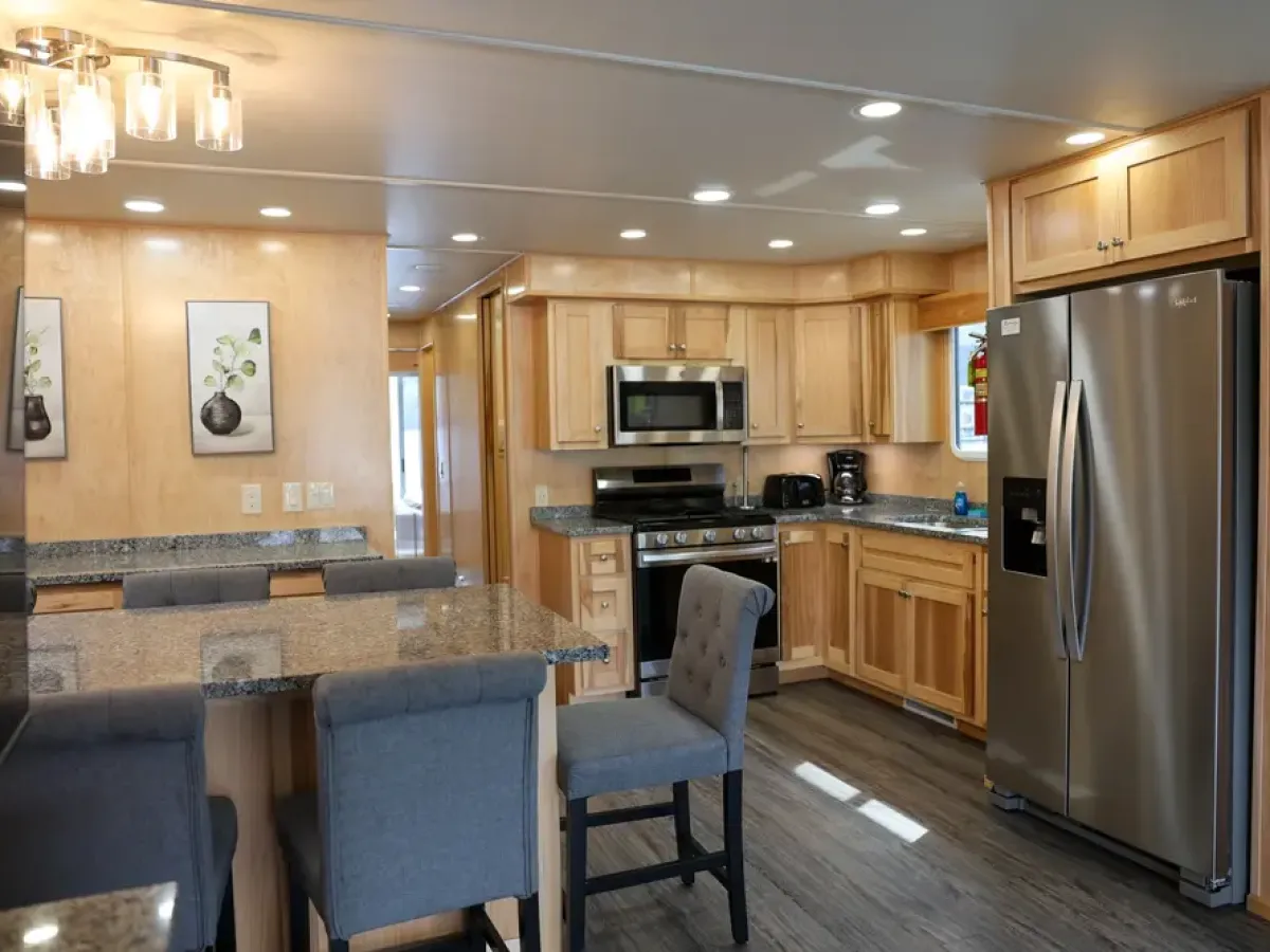 Modern kitchen with wooden cabinets, stainless steel appliances, and granite countertops.