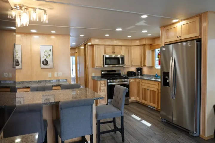 Modern kitchen with wooden cabinets, stainless steel appliances, and granite countertops.