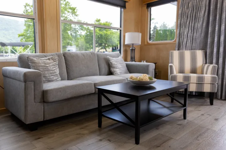 Living room with gray sofa, striped armchair, and black coffee table.